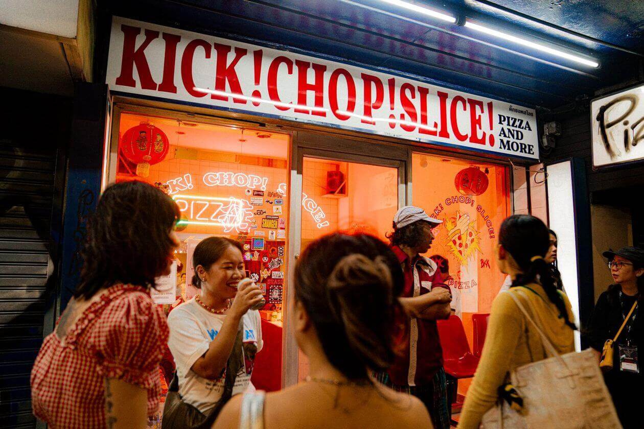 Kick Chop Slice storefront glowing at night - Charoen Krung branch